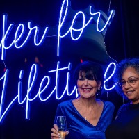 Woman and President Mantella in front of neon sign